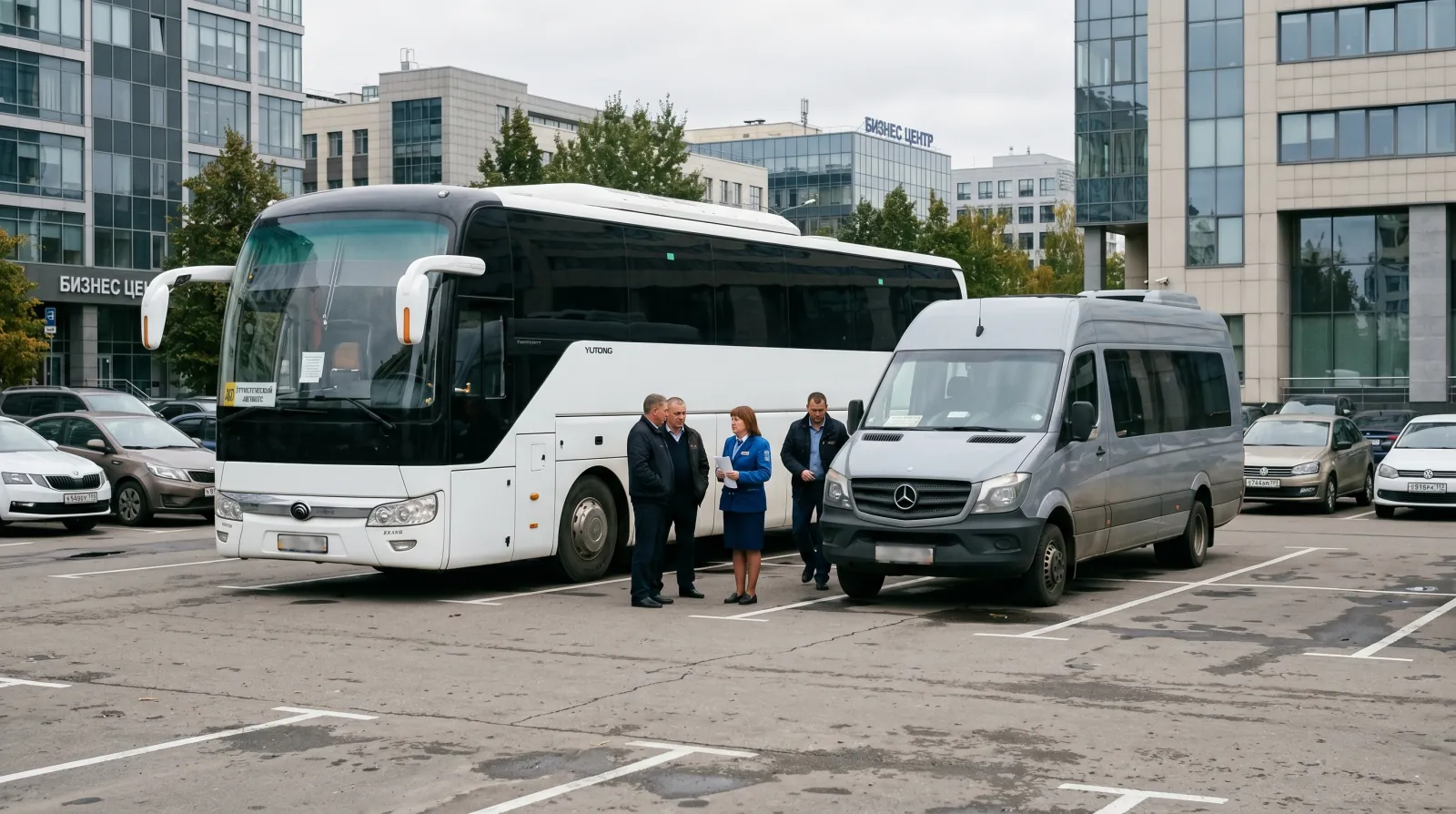 Большой туристический автобус на 50 мест рядом с микроавтобусом на корпоративной парковке